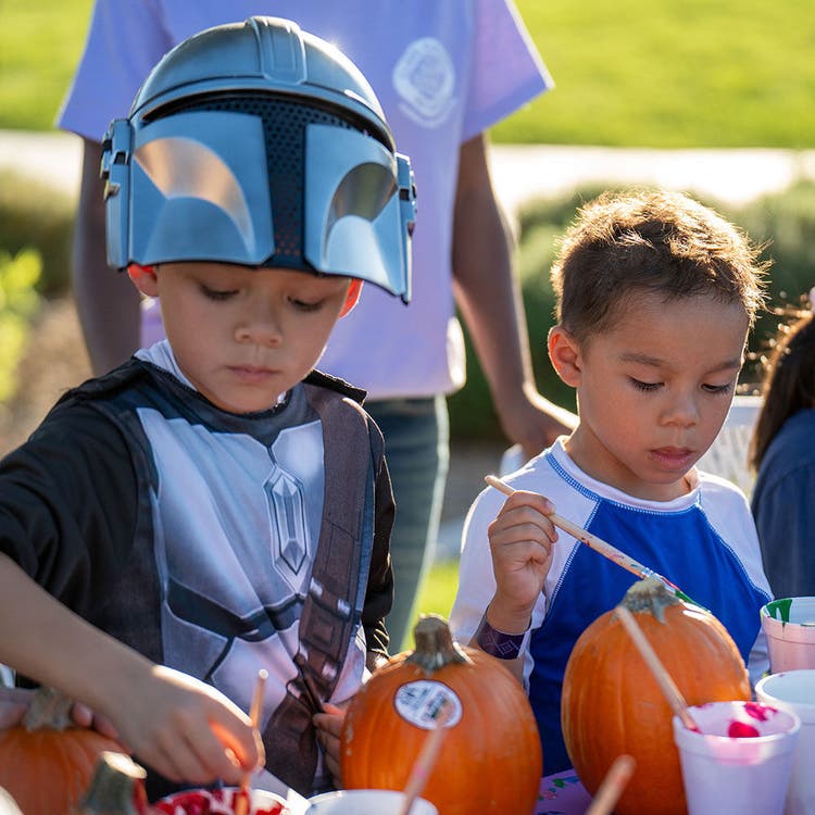 Children Painting Pumpkins Outdoors