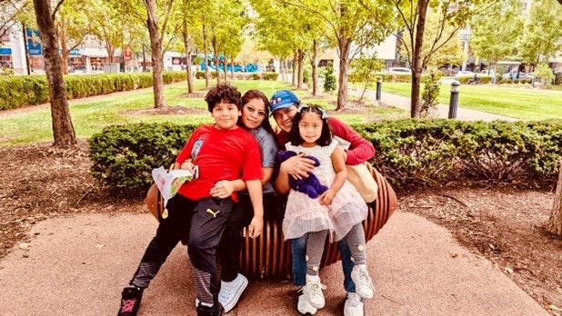 Family sitting on park bench outdoors