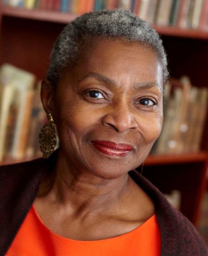 Elderly woman in orange top, library setting